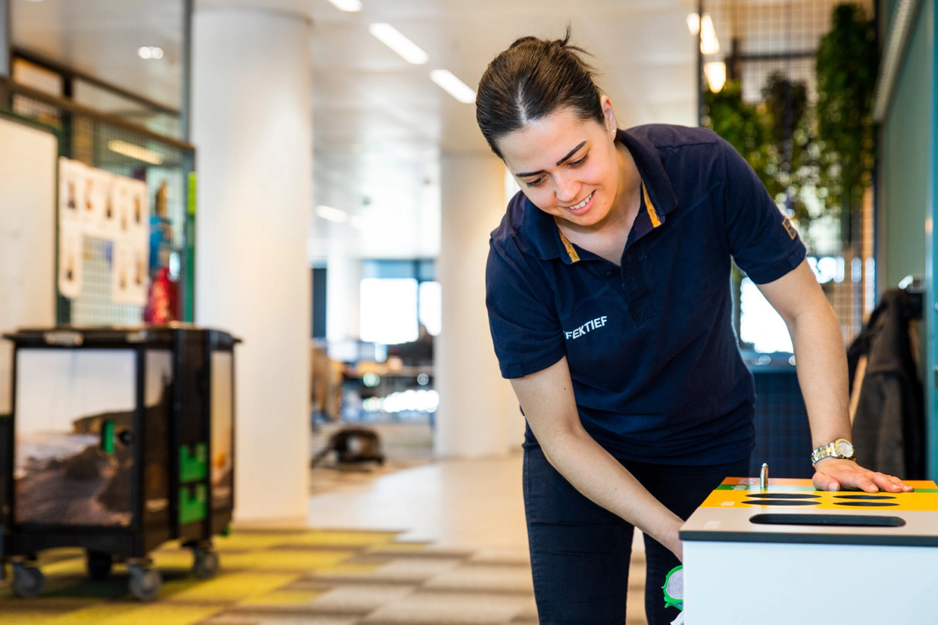 Schoonmaakmedewerker aan het werk tijdens kantoorschoonmaak in een kantooromgeving